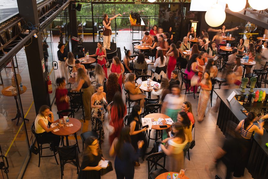 Vista de cima do salão cheio de mulheres em mesas durante o Elas no Bar
